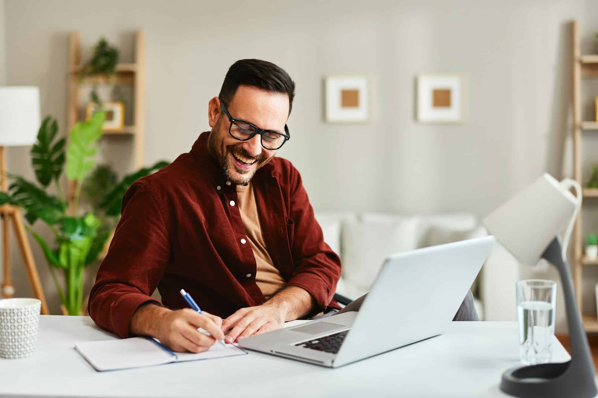 Young business man working at home with laptop and papers on desk