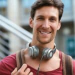 Portrait happy young man smiling confident feeling positive in city urban success testimonial