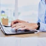 Close up hands of business woman typing on laptop keyboard. Female entrepreneur sending an email on