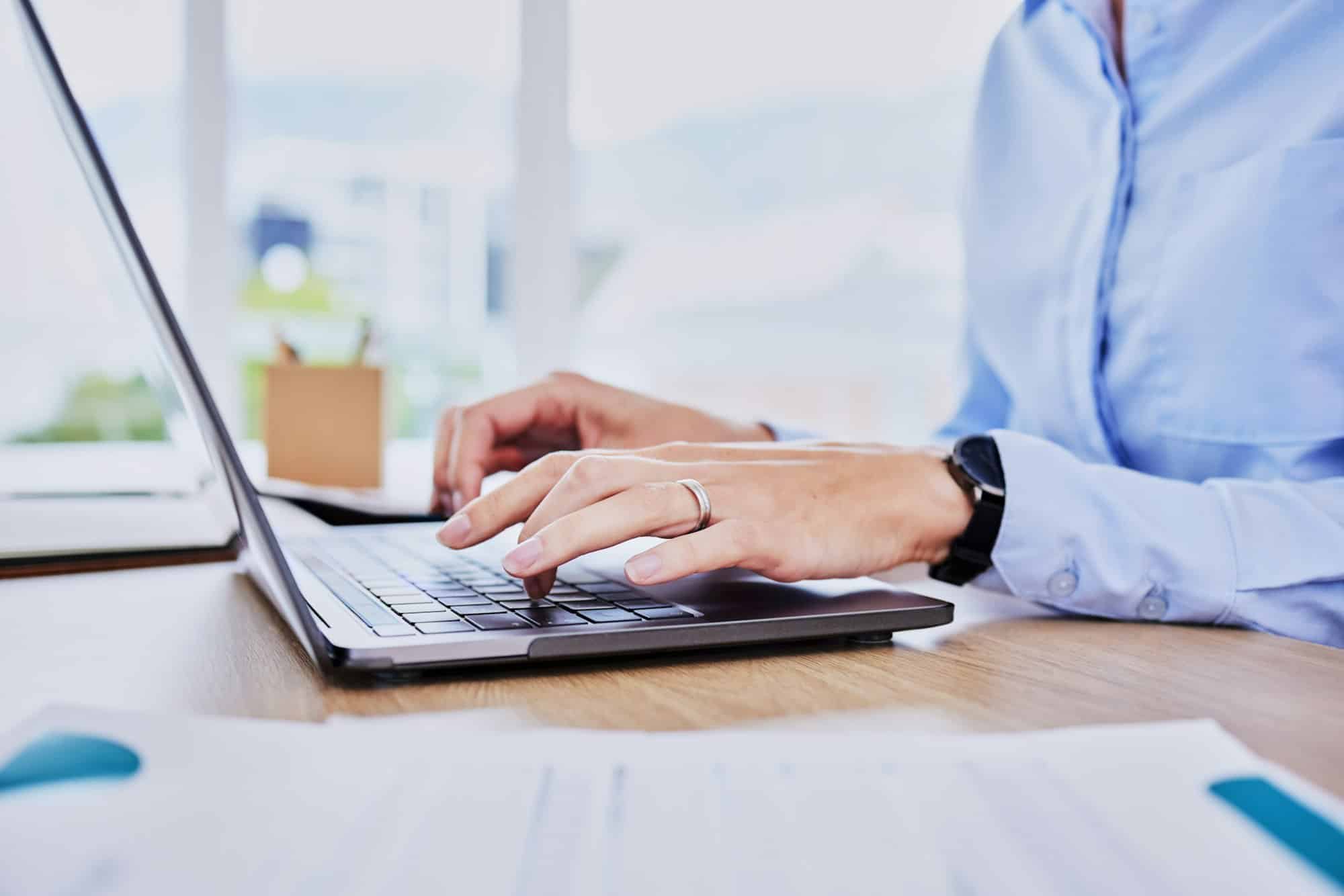 Close up hands of business woman typing on laptop keyboard. Female entrepreneur sending an email on